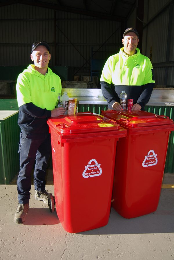 Andrew and Mark in hi-vis yellow jumpers with bottles and cans and the red wheelie bins with South Coast Recycling logo in white for the new bottle and can collection service.